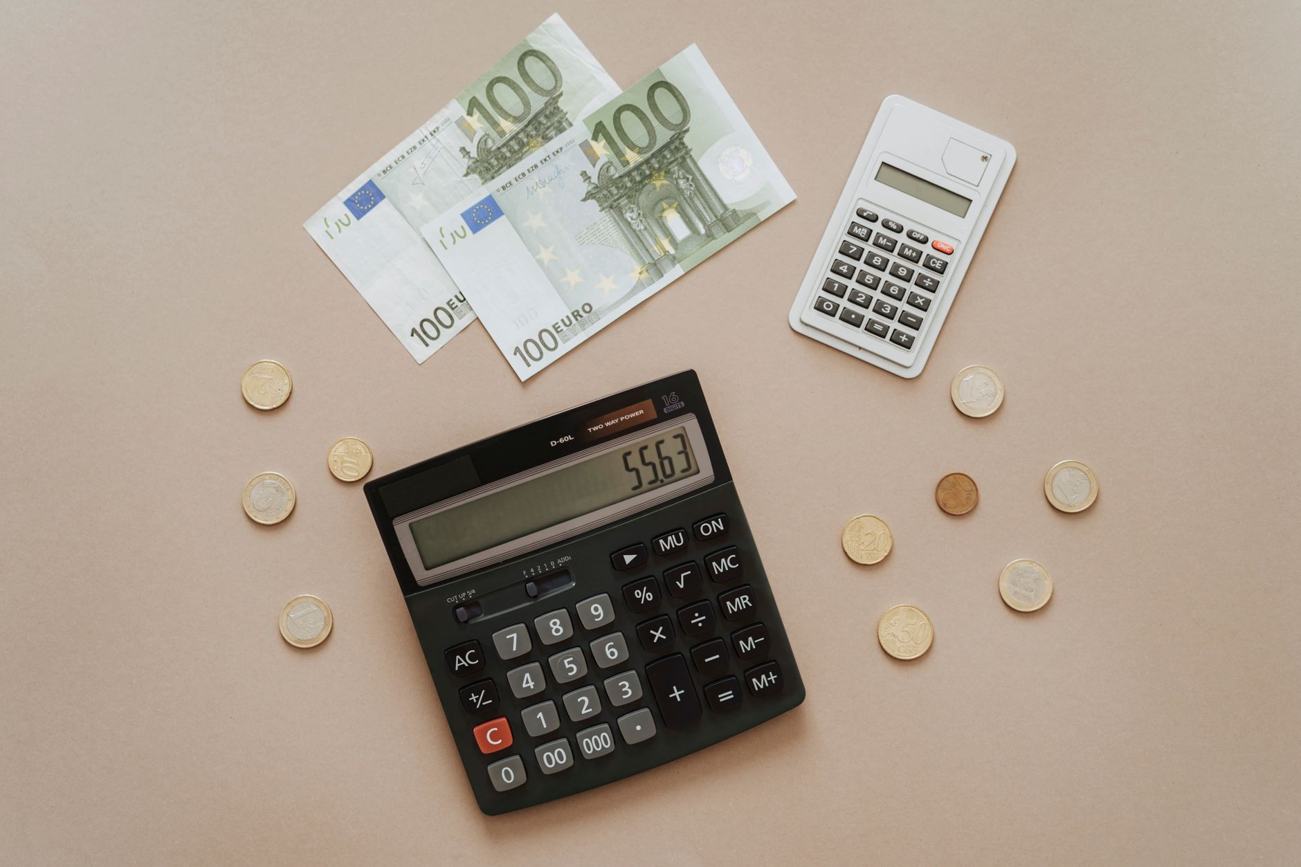 De kosten van een creditcard berekenen met een rekenmachine en muntgeld